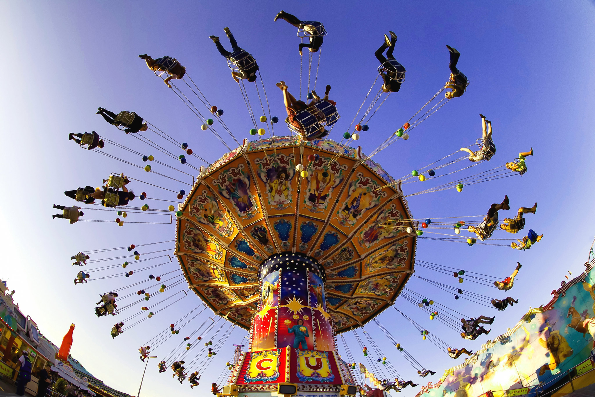 People enjoy the ride on a carousel during a sunny afternoon at the Oktoberfest in Munich
